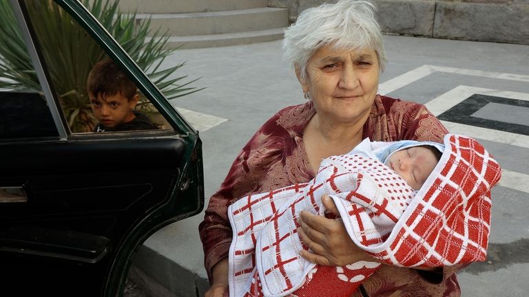 Ethnic Armenian Margarita from Nagorno-Karabakh sits with a child after...