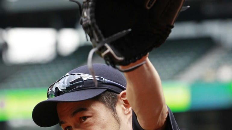 Ichiro Suzuki waves to fans as he heads onto the...
