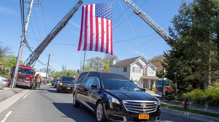 A hearse transports fallen Marine Sgt. Robert Hendriks from Whitting...