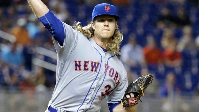 New York Mets starting pitcher Noah Syndergaard throws to first...