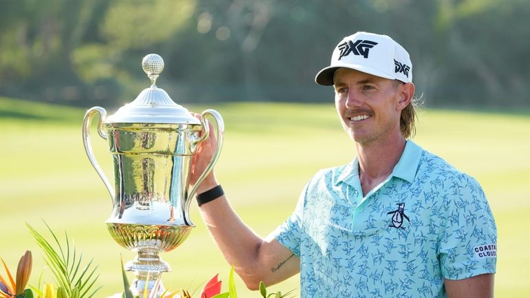 Jake Knapp, of the United States, poses with his trophy...