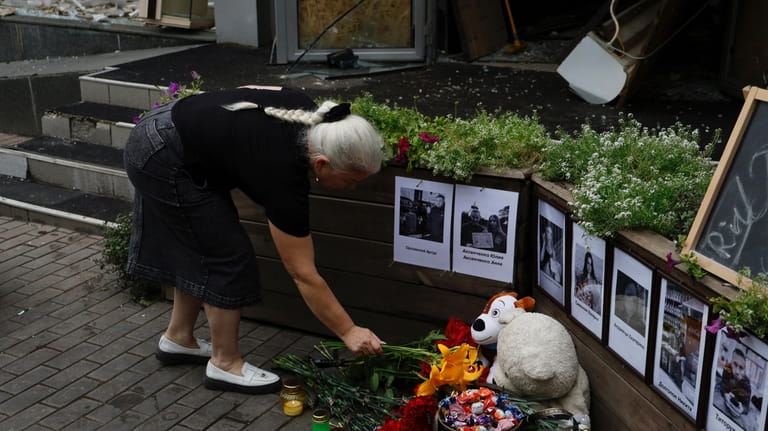 A local woman places flowers at the memorial display at...