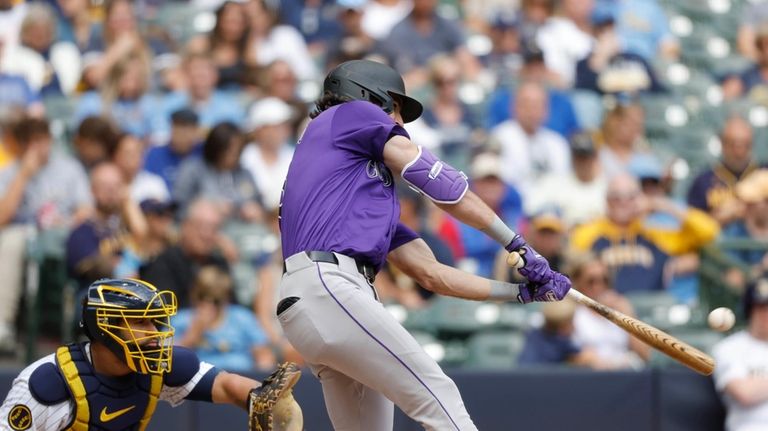 Colorado Rockies' Sam Hilliard, right, hits a three-run home run...