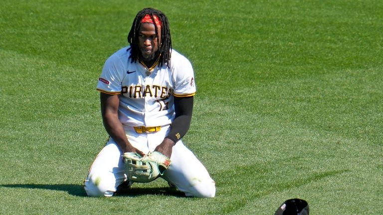 Pittsburgh Pirates centerfielder Oneil Cruz collects himself after diving for...