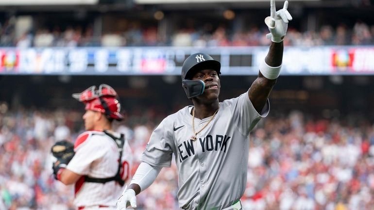 Yankees' Jazz Chisholm, right, reacts after his solo home run...