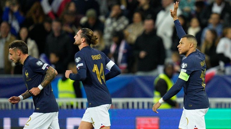 France's Kylian Mbappe, right, celebrates after scoring his side's fourth...