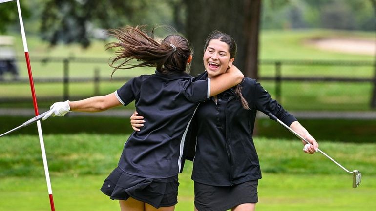 Grace London of St. Anthony's, right, is hugged and congratulated by...