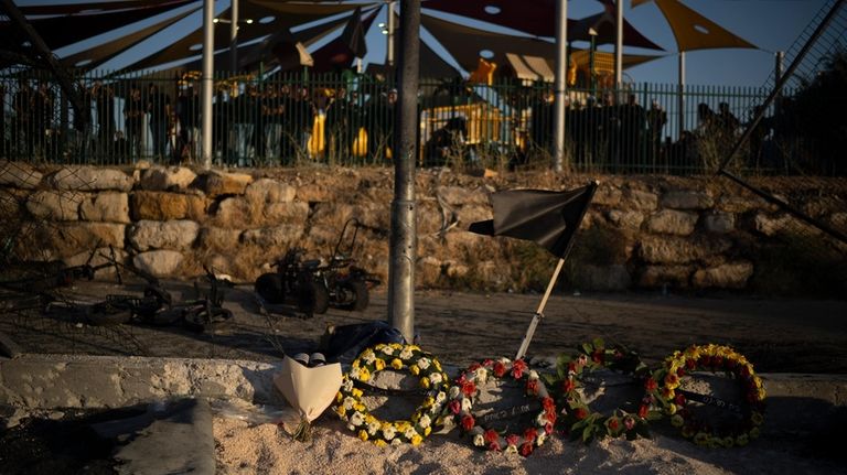 Wreath of flowers are placed on the site of a...