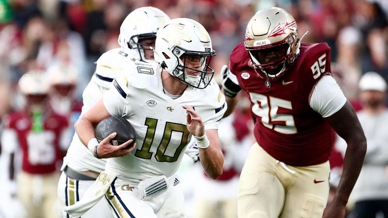 Georgia's Haynes King, left, and Florida's Daniel Lyons challenge for...