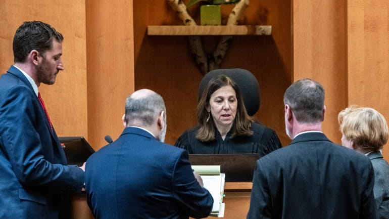 Superior Court Justice Amy Messer talks with the lawyers during...