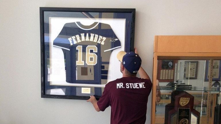 Alonso High School custodian Matt Stuewe hangs the school's remaining...