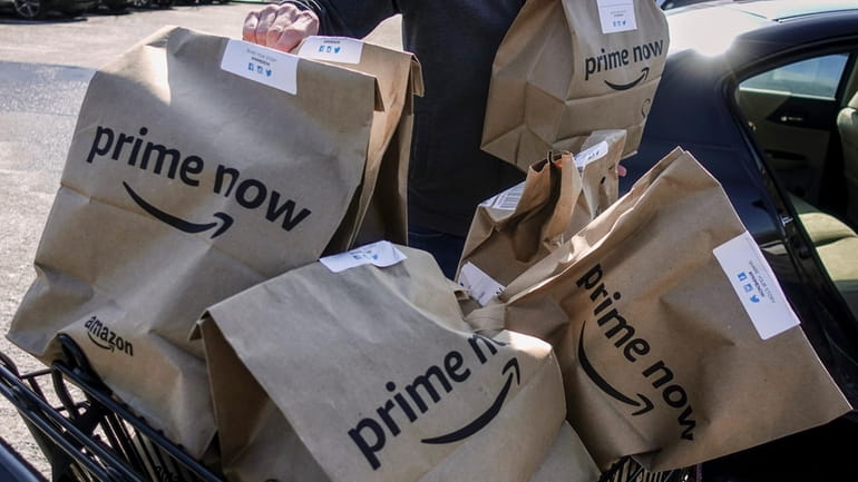 Amazon Prime Now bags are loaded for delivery outside a...