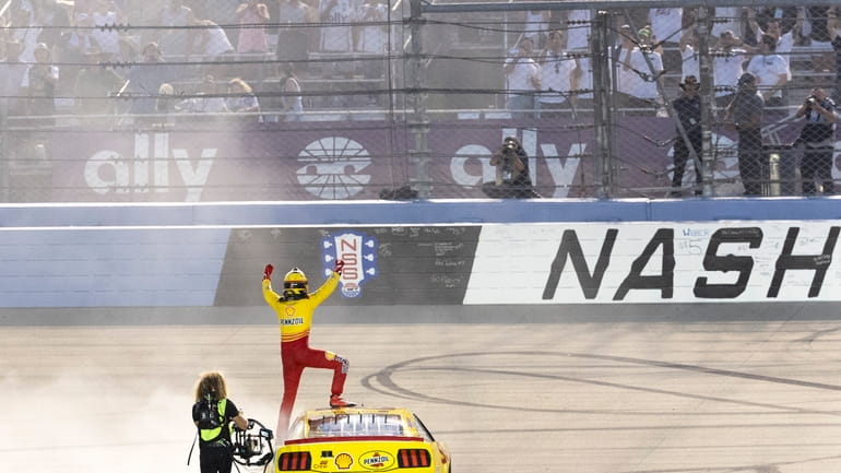 Joey Logano acknowledges the fans after winning a NASCAR Cup...
