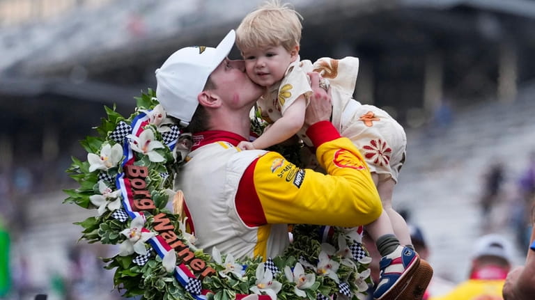 Josef Newgarden kisses his son, Kota, after winning the Indianapolis...