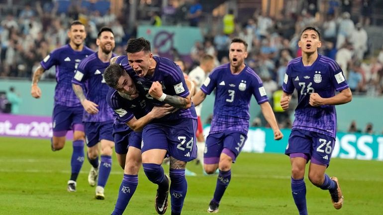 Argentina's Julian Alvarez, front left, is embraced by teammate Enzo...