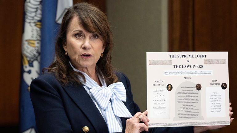 Louisiana Attorney General Liz Murrill speaks holds up a mini-display...