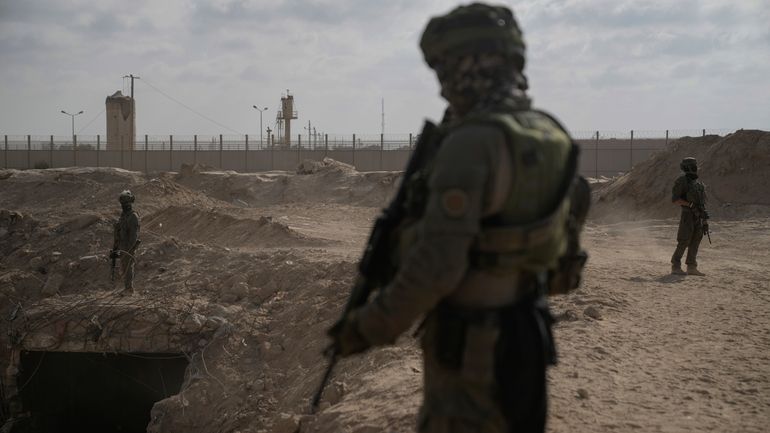 Israeli soldiers take up positions next to an entrance of...