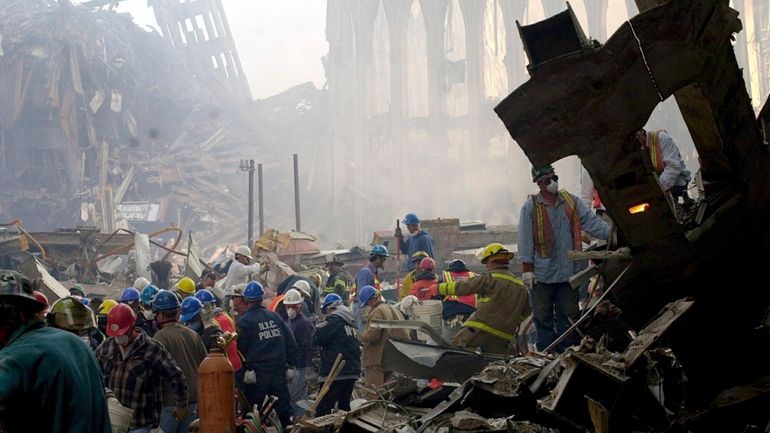 Rescue workers removing debris as they search for survivors at...