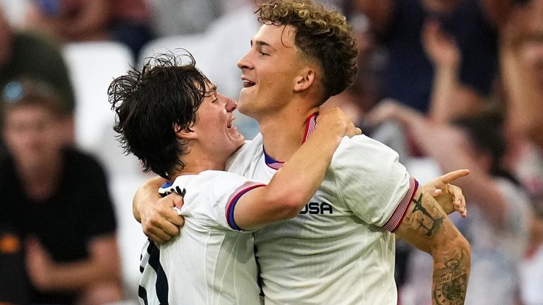 United States' Paxten Aaronson, left, celebrates scoring his side's fourth...