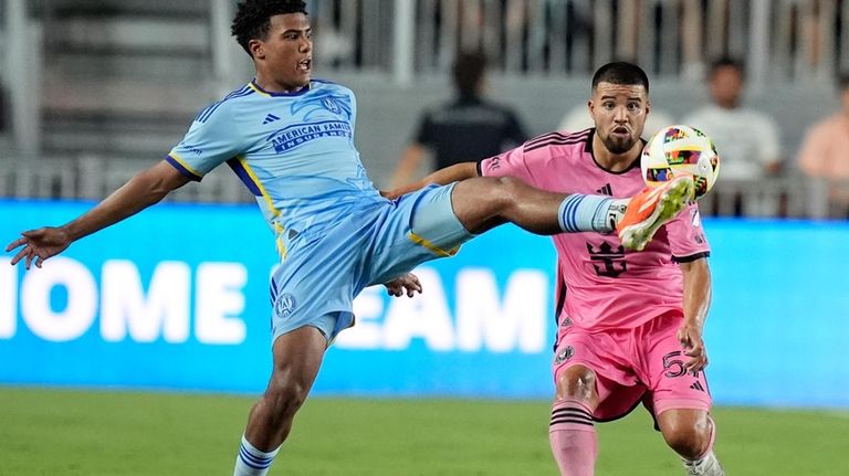 Atlanta United defender Caleb Wiley, left, kicks the ball as...