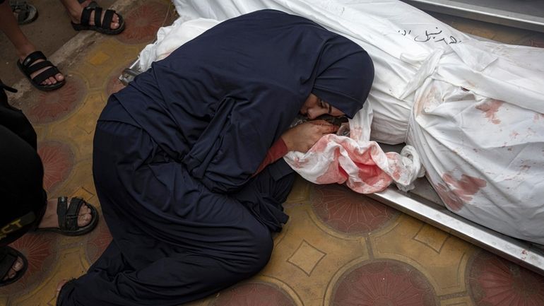 A woman mourns her child and her husband child killed...