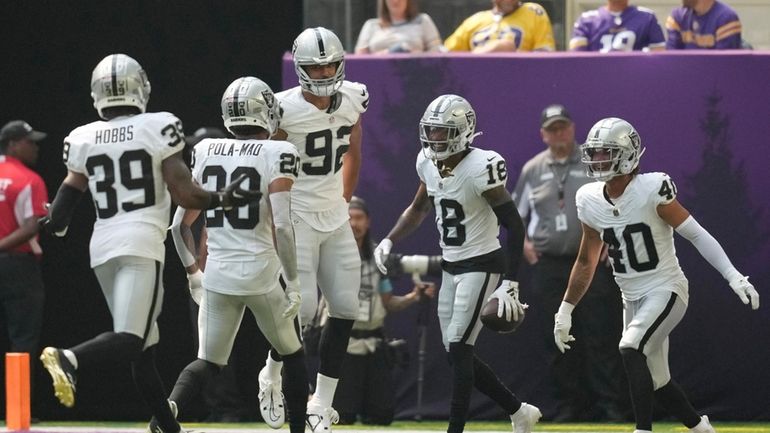 Las Vegas Raiders cornerback Jack Jones (18) celebrates with teammates...