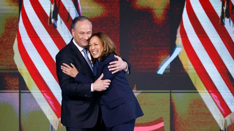 Second gentleman Doug Emhoff, left, hugs Democratic presidential nominee Vice...