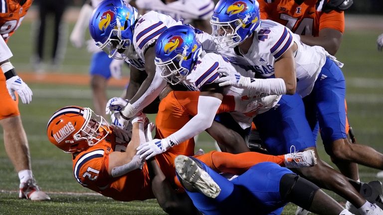 The Kansas defense gang tackles Illinois running back Aidan Laughery...