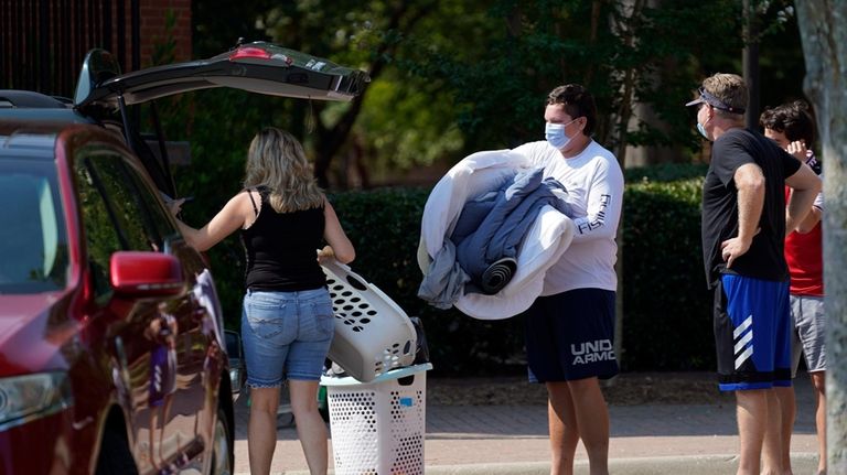 Students and parents begin to move student's belongings out of...