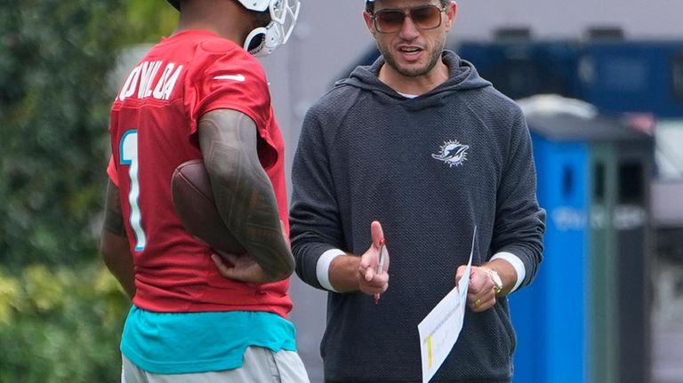 Miami Dolphins head coach Mike McDaniel talks to quarterback Tua...