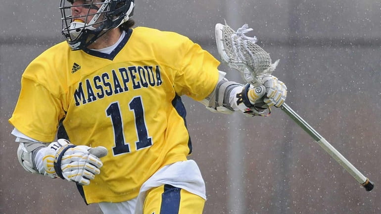 Massapequa's Craig Berge carries behind the net during the first...