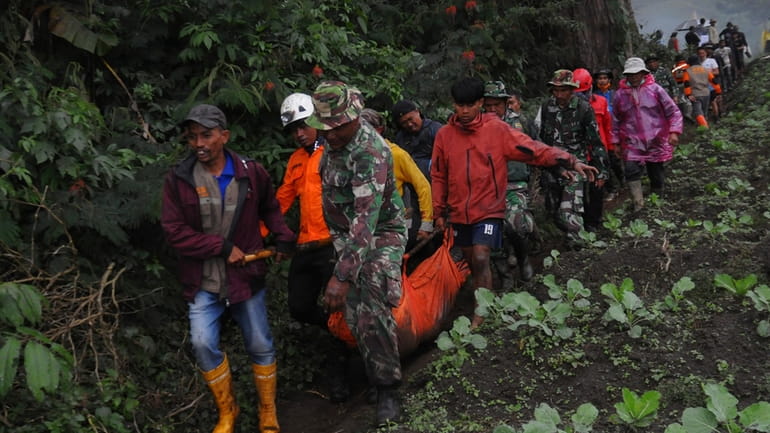 Rescuers carry the body of a victim of the eruption...