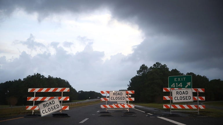 Road closed signs sit on Rt40 due to flooding, on...
