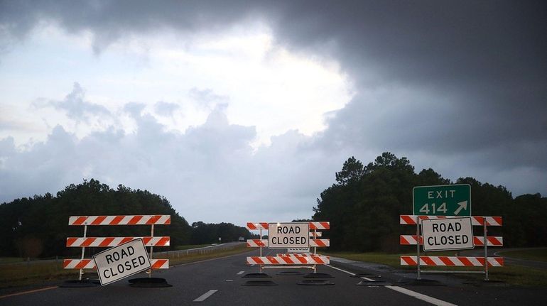 Road closed signs sit on Rt40 due to flooding, on...