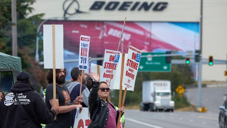 Boeing Machinists Union member Stephanie Corona waves to passing traffic...