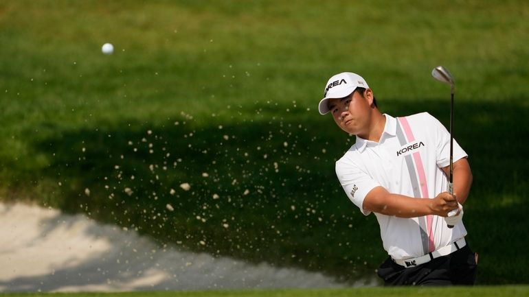 Tom Kim, of South Korea, plays from a bunker on...