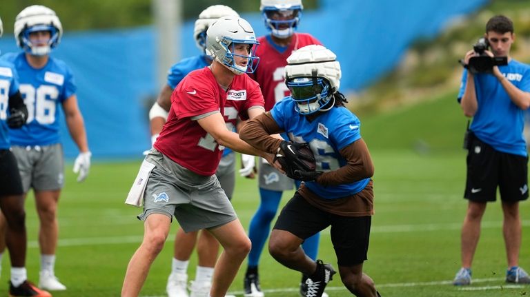 Detroit Lions quarterback Jared Goff (16) hands off to running...