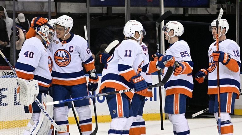 Islanders goaltender Semyon Varlamov, Anders Lee and teammates celebrate their...