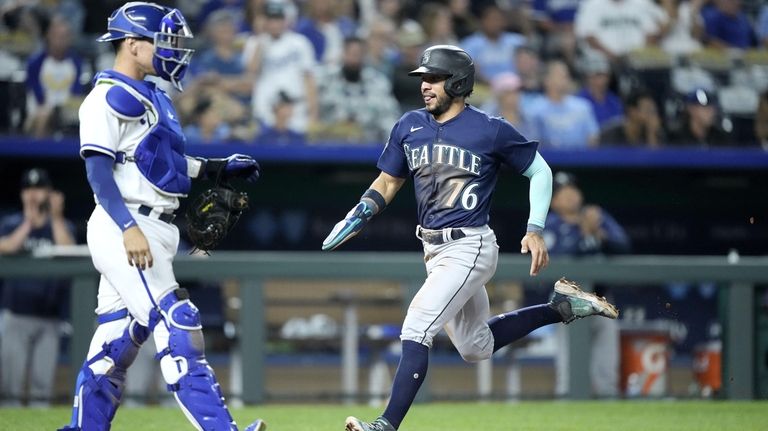 Seattle Mariners' Jose Caballero (76) runs home to score on...