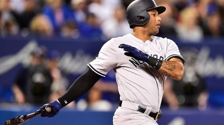 New York Yankees' Aaron Hicks follows through on a single...