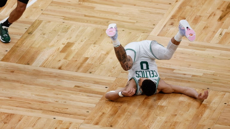 Boston Celtics forward Jayson Tatum (0) falls to the court...