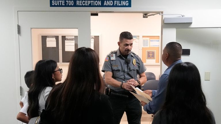 An officer listens to a question as he directs people...