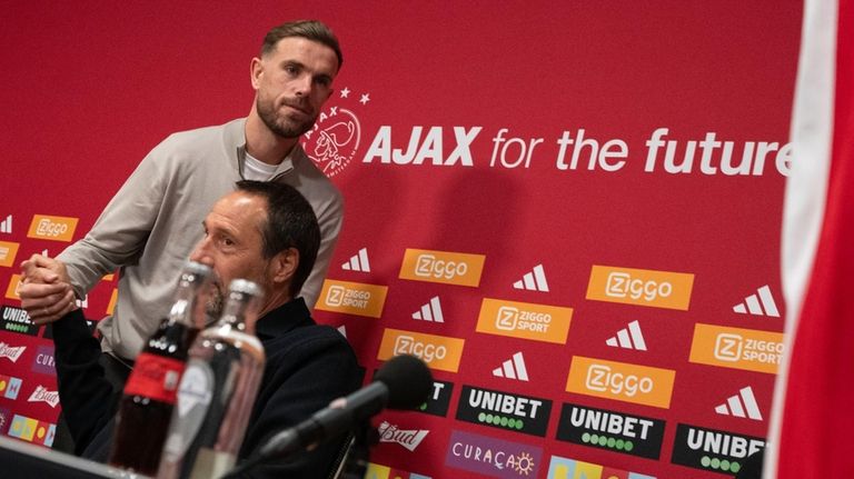 England midfielder Jordan Henderson, top, shakes hands with Ajax trainer...