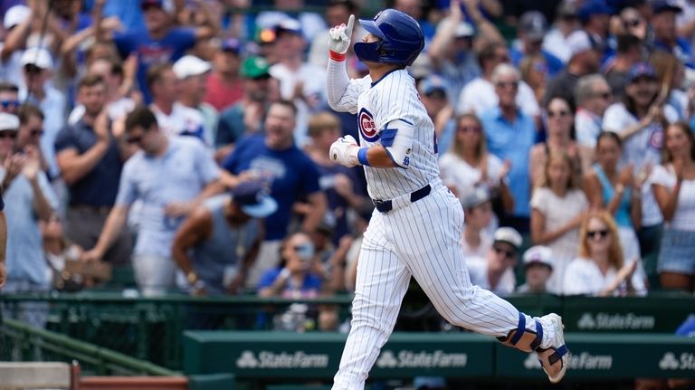 Chicago Cubs' Seiya Suzuki runs the bases on a home...