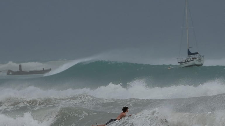 A surfer braves the waves in Carlisle Bay as Hurricane...