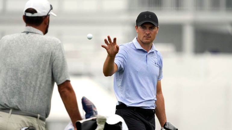 Jordan Spieth, right, catches a ball tossed to him on...