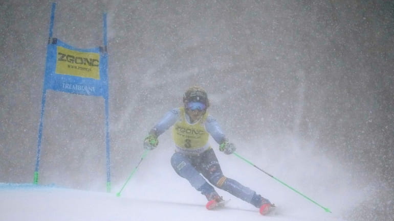 Heavy snow obscures Federica Brignone of Italy as she speeds...
