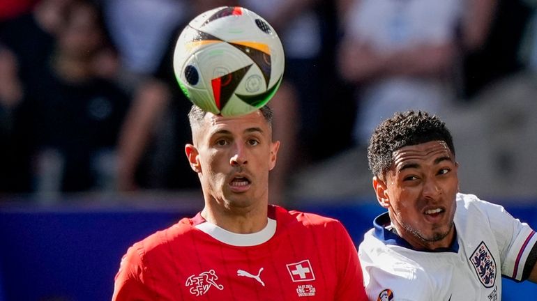 Switzerland's Fabian Schar, left, vies for the ball with England's...