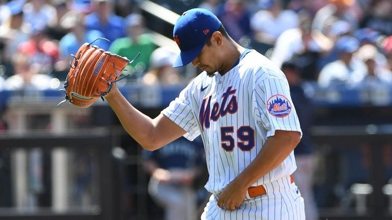 Mets starting pitcher Carlos Carrasco walks to the dugout after...