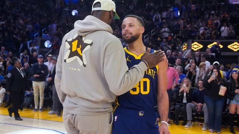 Injured Los Angeles Lakers forward LeBron James, left, talks to...